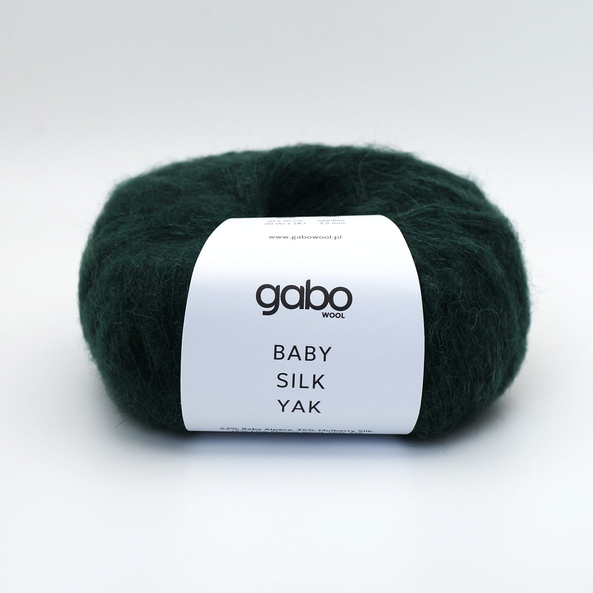 A ball of dark forest green yarn with a white paper label reading 'gabo WOOL BABY SILK YAK', photographed on a clean white background.