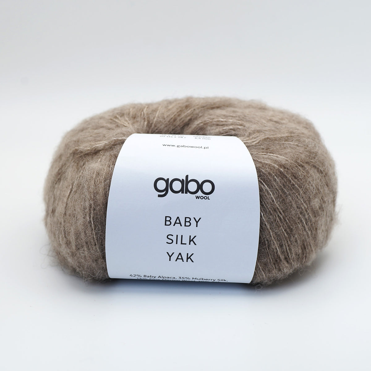 A ball of Gabo Wool Baby Silk Yak yarn in a light taupe-brown color, wrapped with a white paper label, on a clean white background.